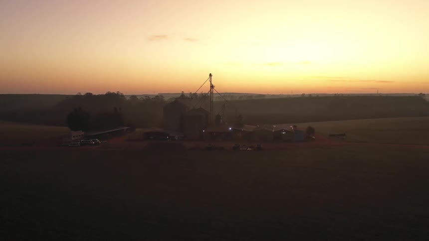Farm with silos seen from above at sunrise