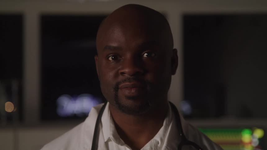 The doctor turns his head and smiles