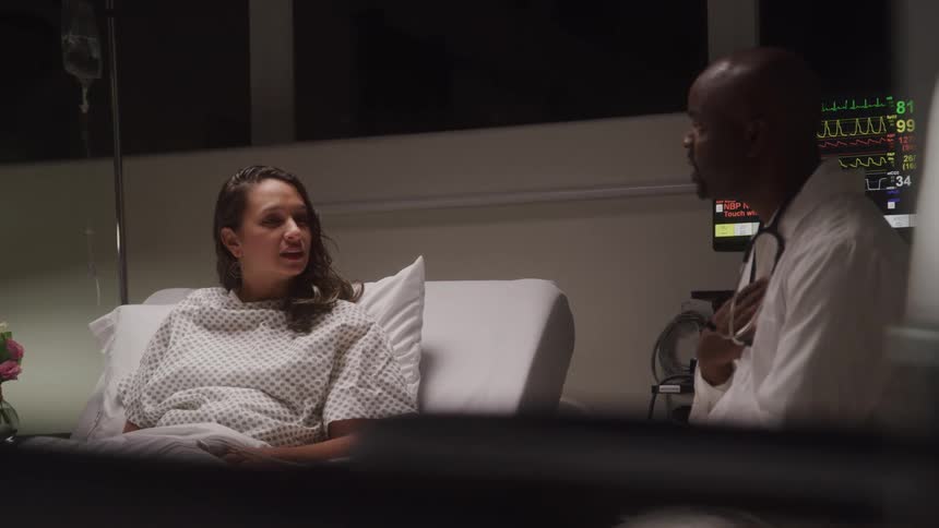 Doctor talking to a patient lying in a hospital room