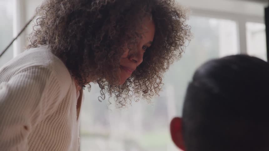 The woman leans over the man and nods