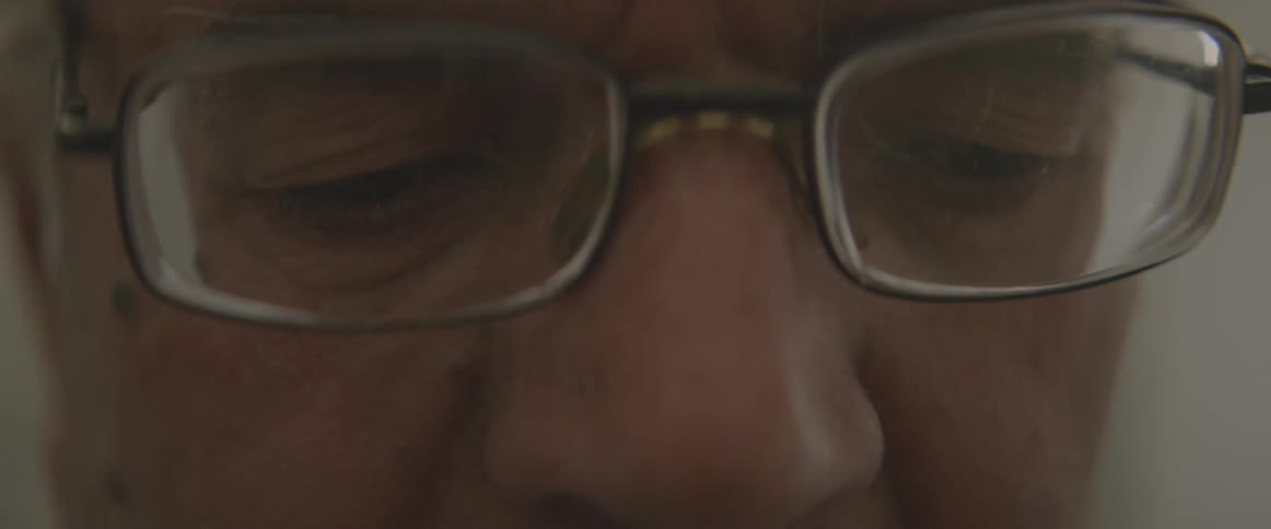 A man concentrates while wearing glasses