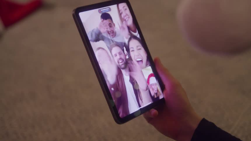 Mobile phone screen displaying people on a video call with happy expression