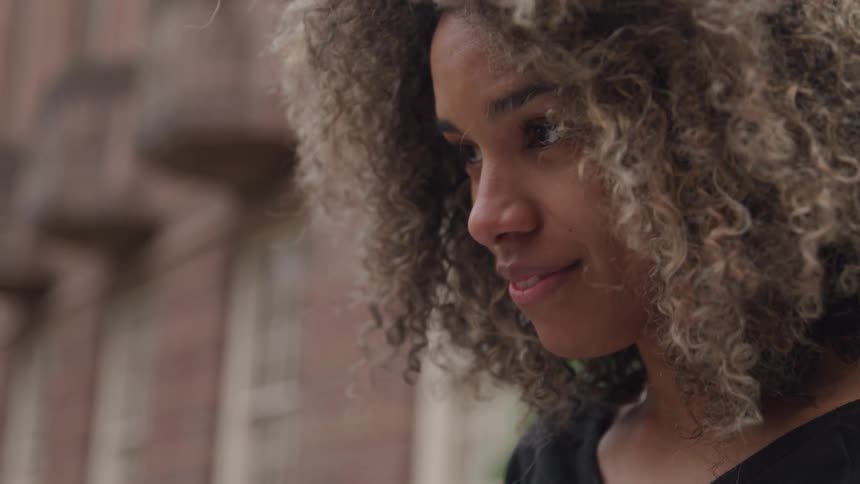 A woman smiles at something off camera