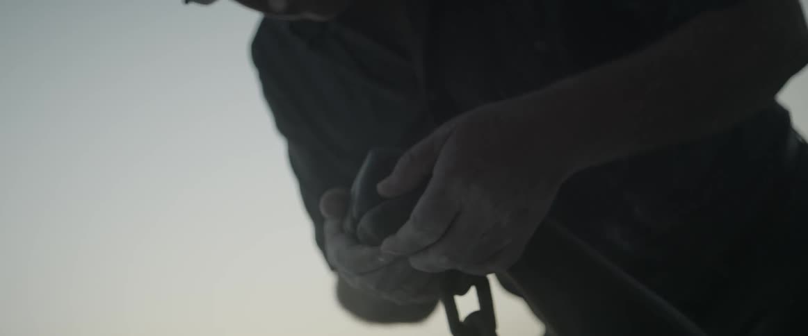 A man is tracing his hand over some stone