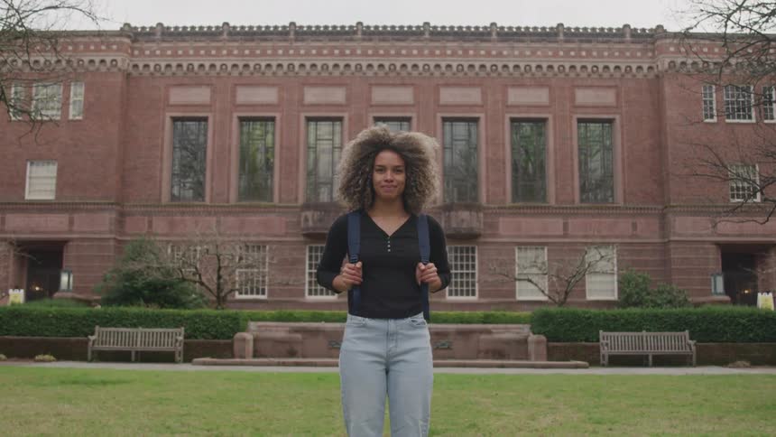 Female student standing on front lawn of campus university