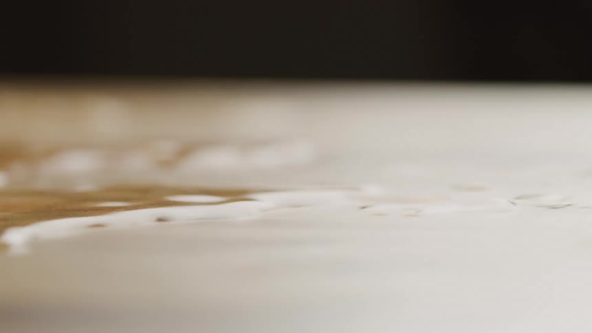 Water spilled on a surface vibrating and causing the water to ripple and move