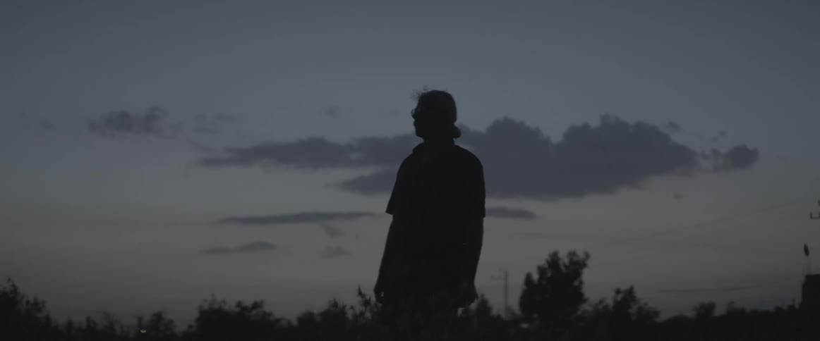 A man stands on a field at dawn