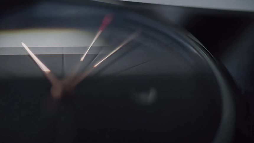 An extreme closeup of a watch dial with a sleek glass surface