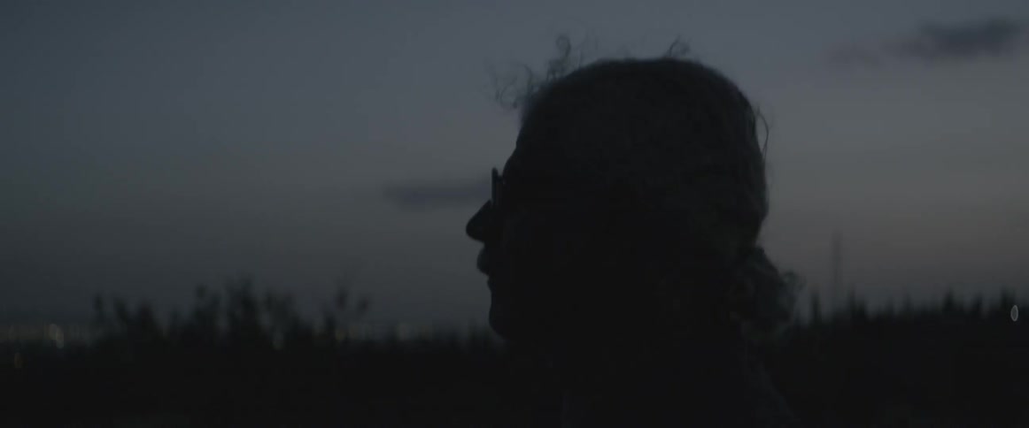 An elderly man stares into the distance
