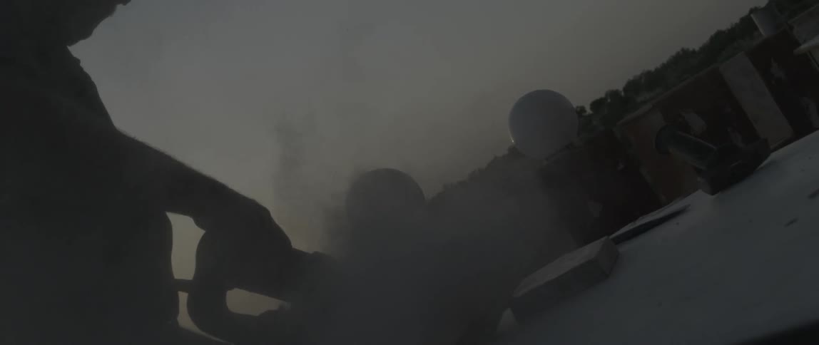 A man is sanding stone on a rooftop
