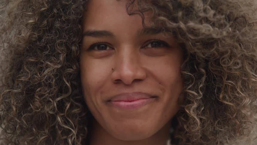 Woman with curly hair is smiling