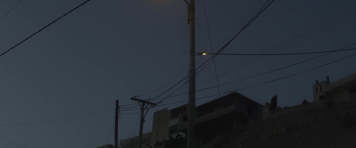 Power lines line the dark dawn sky