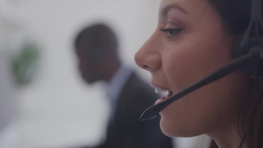 Girl speaking through a headset microphone in a call centre