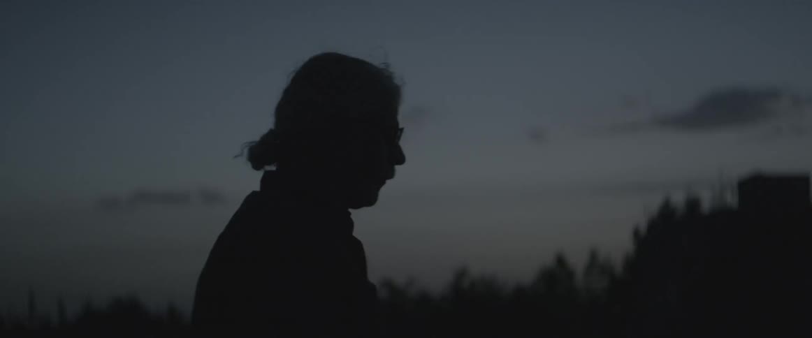 A man walks outdoors at dusk
