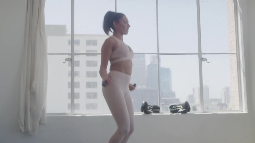 Woman in an indoor space jumping rope