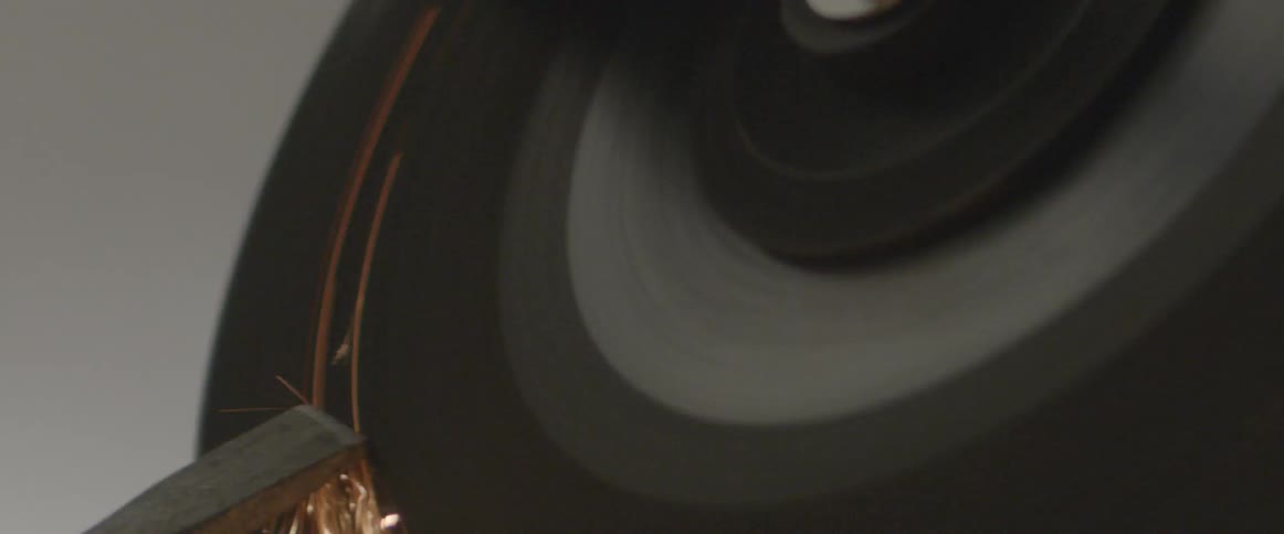 Metal is held against a grinding wheel causing sparks