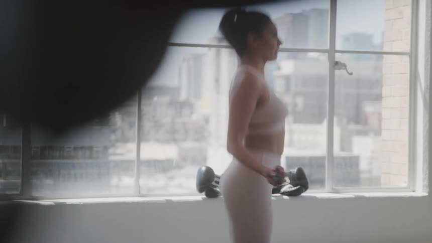 A young woman skipping rope in a gym at midday