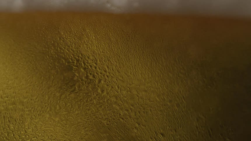 Golden carbonated liquid with a foamy head