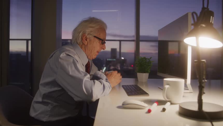 The man is working at his desk on the computer