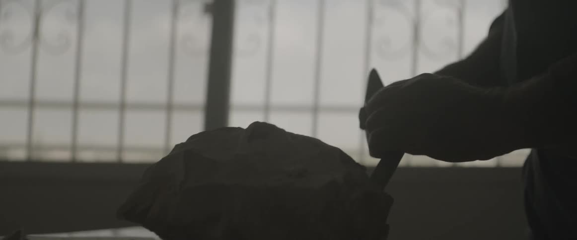 A man is chiseling some stone