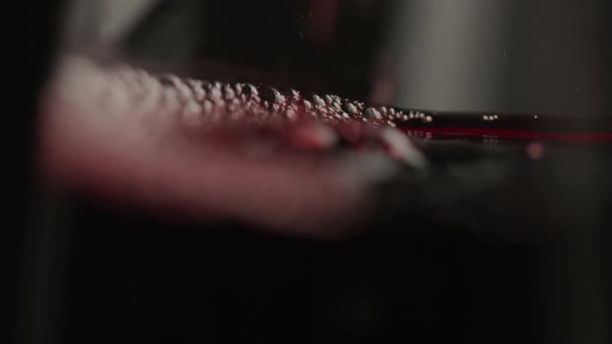 Red wine is being poured into the glass