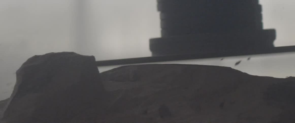 A man works with a grinder on a sculpture