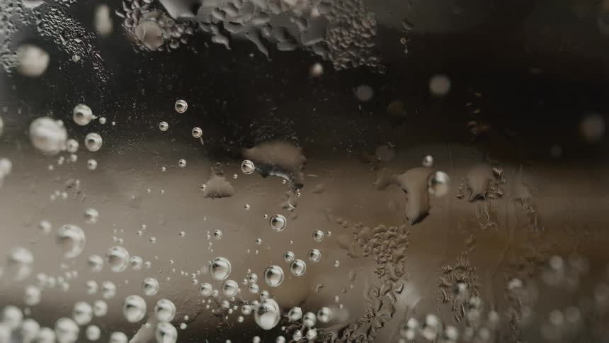 Closeup of a glass texture with carbonated liquid with bubbles