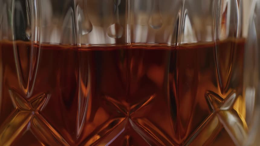 Close up of a glass cup with amber liqueur