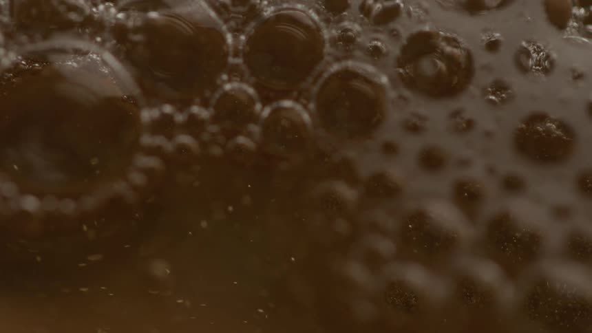 Extreme close up of bubbles forming in yellow liquid