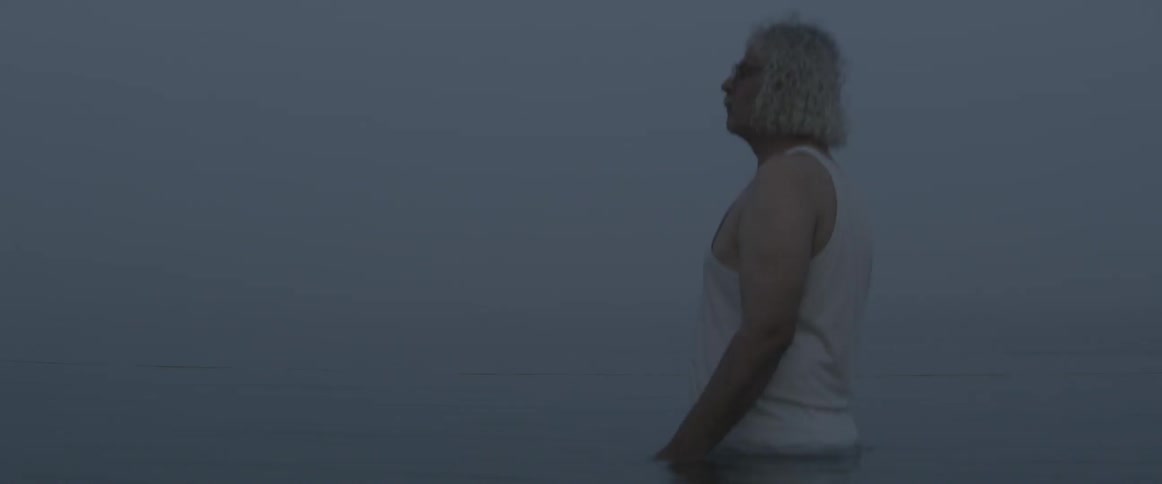 A man looks out over a foggy sky