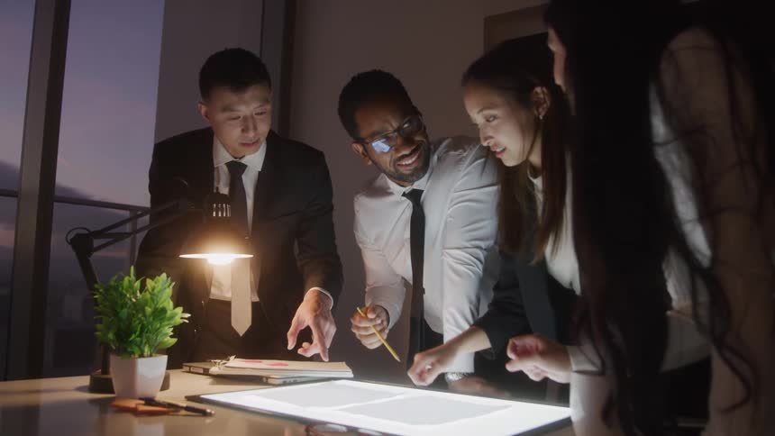Coworkers talk together while looking at papers
