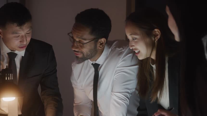 A group of colleagues in the office discussing and looking at a project on a computer screen