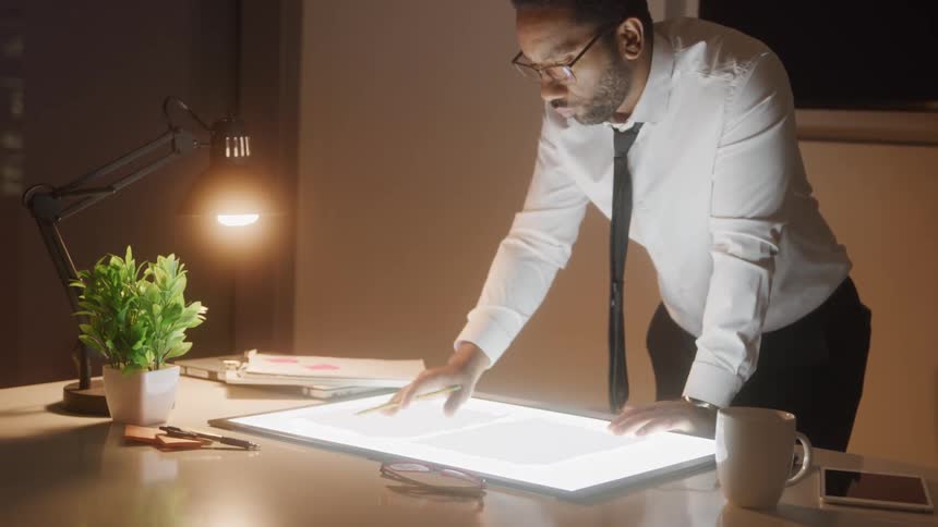 A man is looking over paperwork in the office