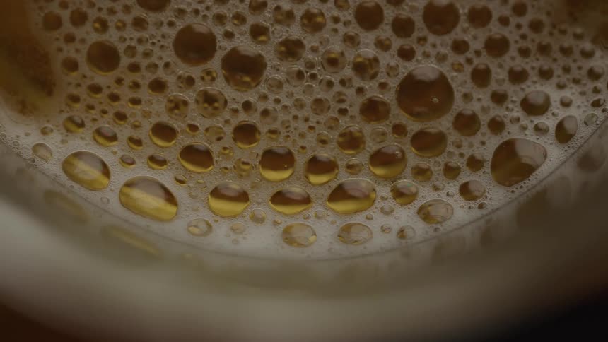 The bubbles slowly pop on the beer