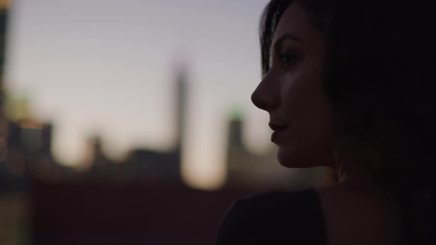 The woman is looking towards the buildings