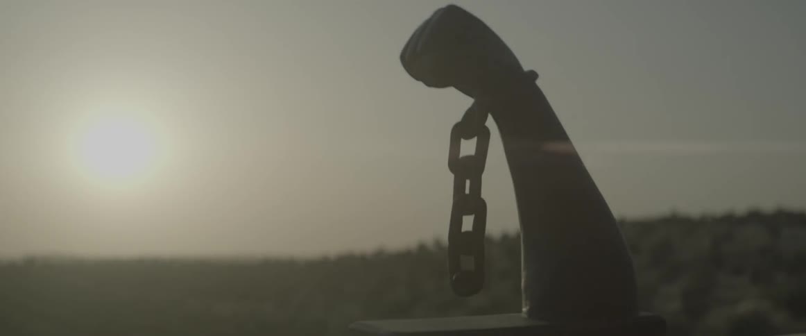 A sculpture of a chained hand outside in the sun
