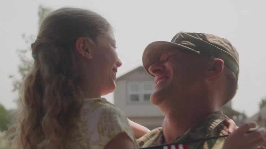 Military father with beret with his daughter on his lap both happy