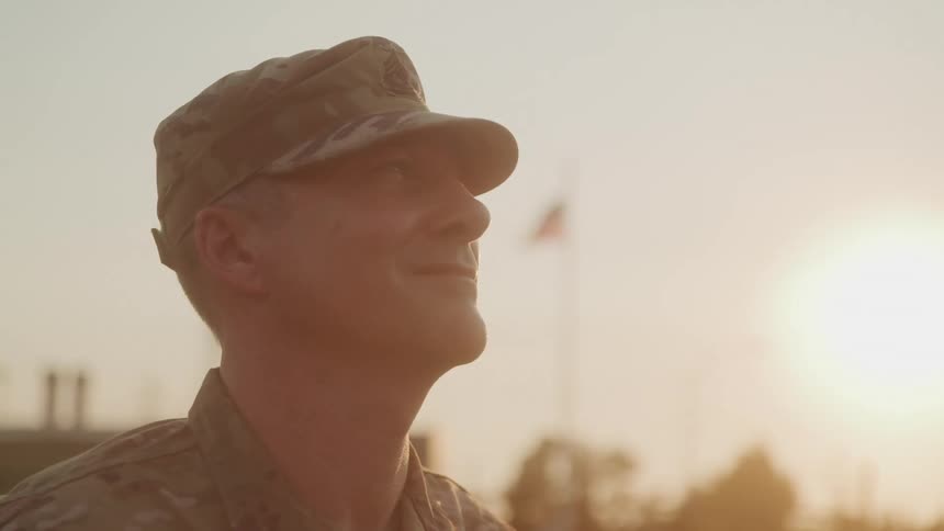 The soldier is looking up and smiling