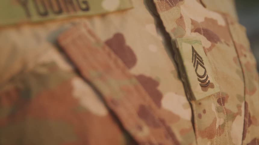 The soldier is wearing a camouflage uniform