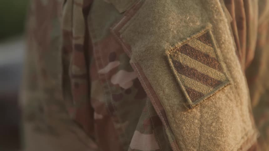 Closeup of a soldiers camouflage uniform with an insignia in focus