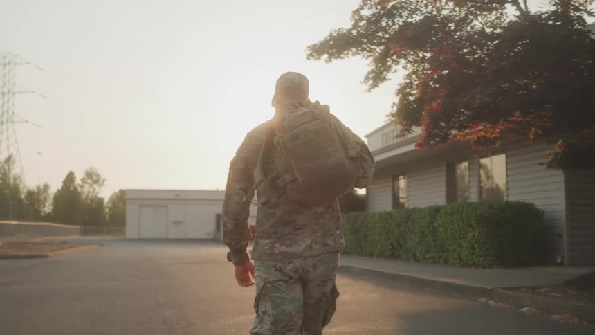 Military man with a bag walking outdoors