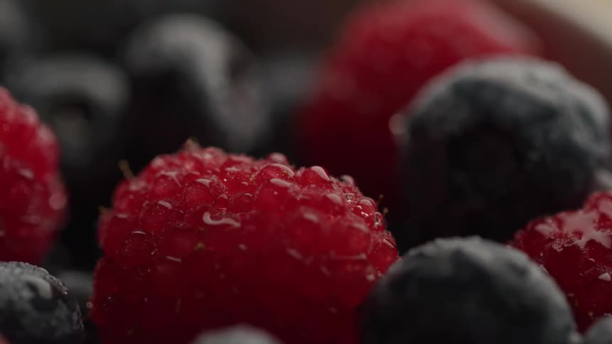 Close up of a rotating bowl of blueberries with raspberries