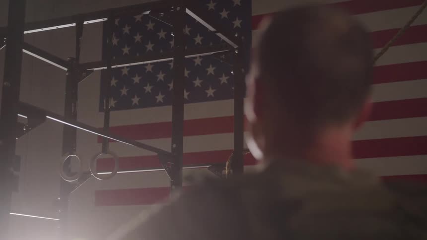 A man looks at an american flag hanging on the wall
