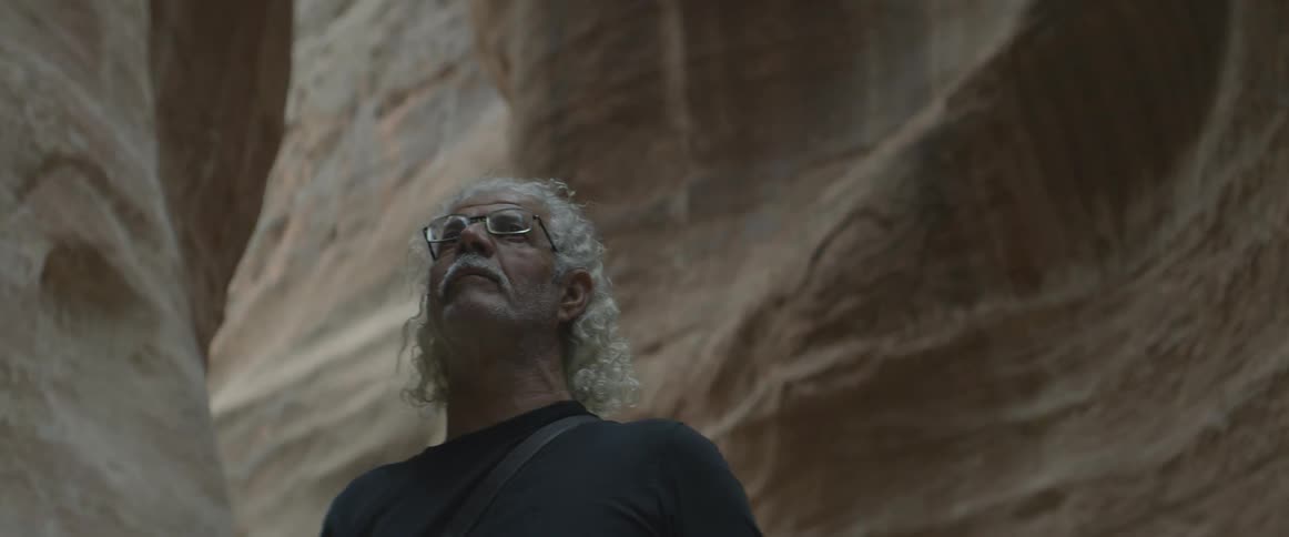 A man looks around in a canyon