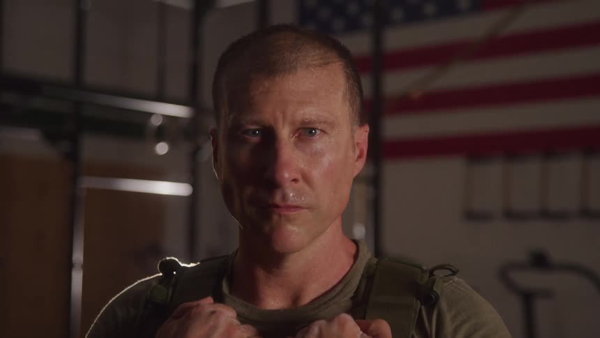 Close up portrait of a military man standing indoors after a workout session