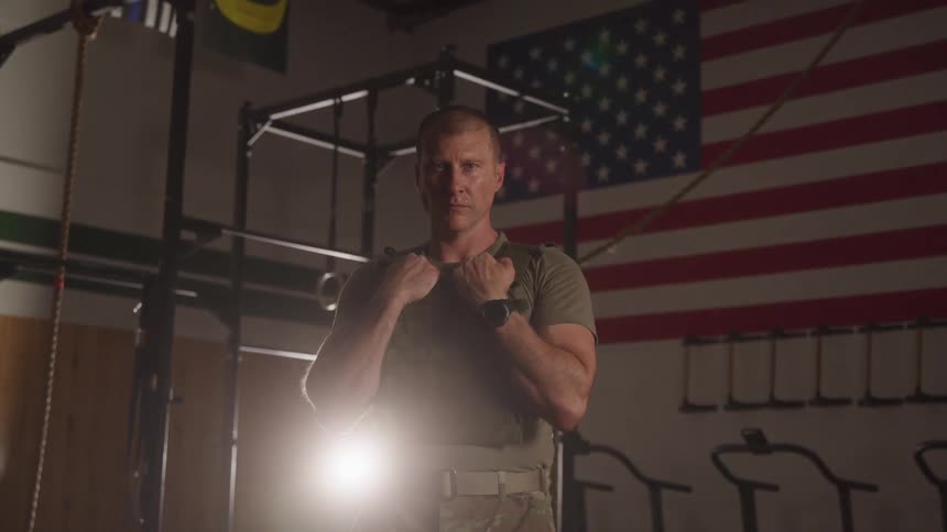The soldier is standing in the gym
