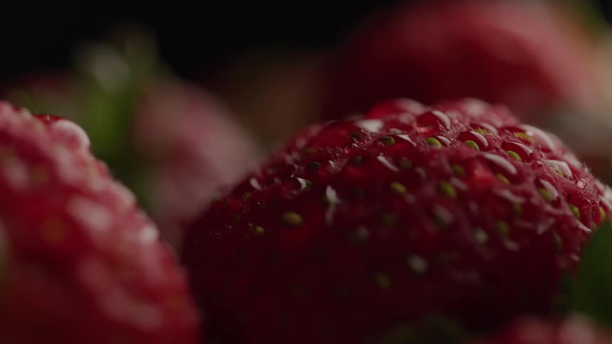 Extreme close up of droplets on a washed red ripe strawberry