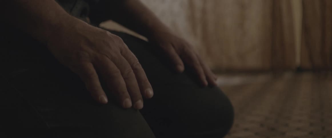 A man is seated on his knees