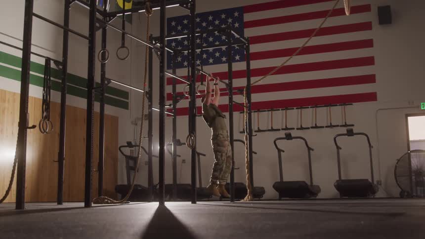 Military man doing pullups at an indoor gym