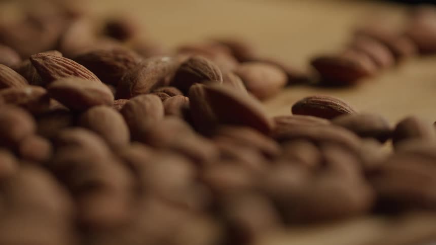 Close up pile of almonds on a wood counter